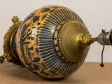 a gold and blue vase sitting on top of a table