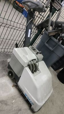 une machine posée par terre à côté d'une poubelle