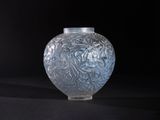 a glass vase that is sitting on a black surface
