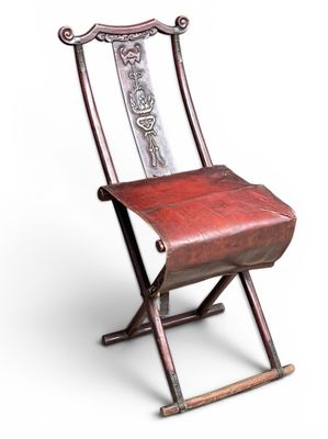 chair made of wood and metal with a red leather seat