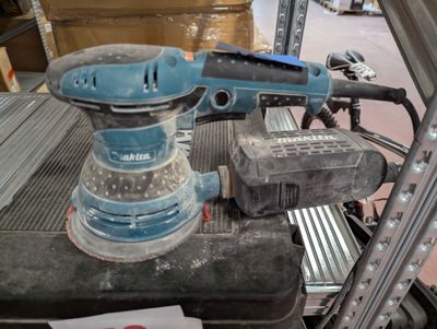 a blue sander sitting on top of a table in a warehouse