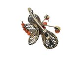 a close up of a brooch with a butterfly on it