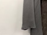 un manteau accroché au mur à côté d'un pantalon
