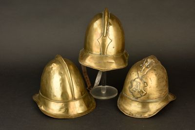 trois casques dorés sont posés les uns à côté des autres sur une surface noire