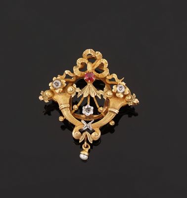 a gold and diamond broochle on a black surface