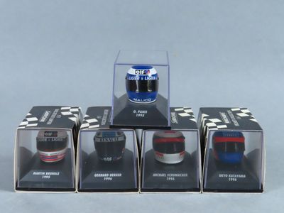quatre voitures miniatures sont exposées dans une vitrine posée sur une surface grise