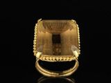 an 18k yellow gold ring set with a faceted green quartz stone