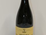 La bouteille de vin rouge est posée sur une table blanche.