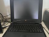a black laptop computer sitting on a desk next to a speaker