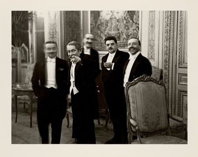 four men in suits standing next to each other in a room