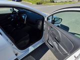 a white car with its door open in a parking lot