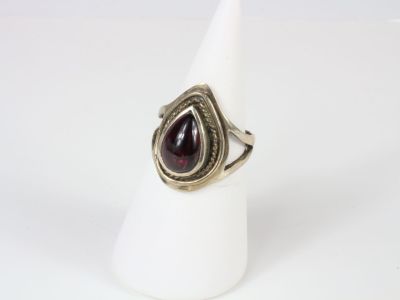a close up of a ring with a tear shaped stone on it