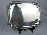 a silver tray with a handle on a stand on a white background