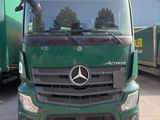 un camion vert garé devant un immeuble