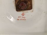 a white toilet with a rusted lid and a rusted drain