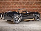 an image of a black sports car parked in front of a brick wall