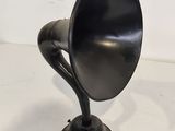 an old fashioned black gramphone sitting on a white surface
