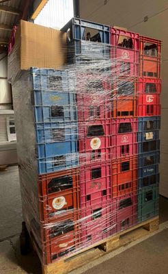 une grande pile de caisses posées sur une palette dans un entrepôt