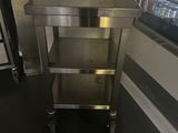a stainless steel kitchen cart in the middle of a room