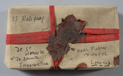 un morceau de papier sur lequel il y a quelque chose d'écrit, entouré d'un ruban rouge