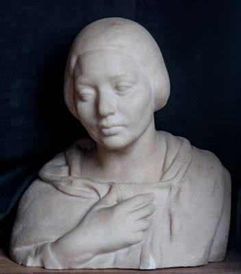 une statue représentant une femme les mains posées sur ses genoux