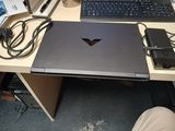 un ordinateur portable posé sur un bureau, à côté d'un clavier