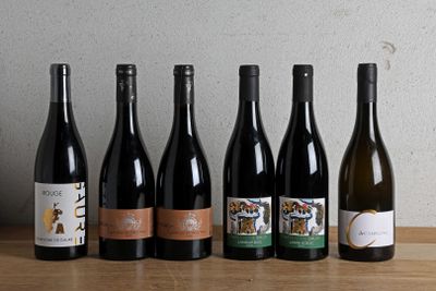 six bouteilles de vin sont alignées sur une table en bois