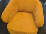 mustard colored chair in a room with a black floor and a black table