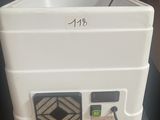 a white cooler sitting on top of a table next to a red wall