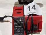a red corded drill with a charger attached to it