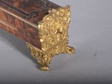 a small wooden box with a gold decoration on it