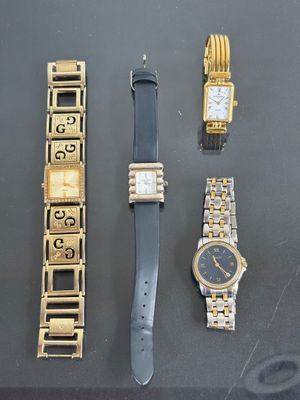 three watches and a watch bracelet are sitting on a table