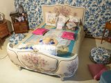 une chambre avec un lit, des commodes et une chaise