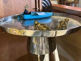 une assiette en argent sur laquelle est représenté un bateau bleu