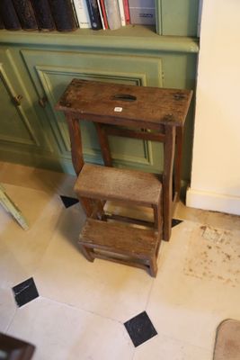 une photo d'une salle de bains avec des toilettes et un tabouret