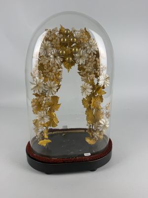 a glass dome with flowers inside of it on a table