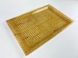 a gold tray with holes on it on a white surface