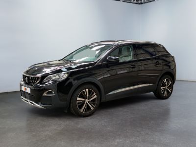 un SUV noir garé dans une pièce aux murs blancs