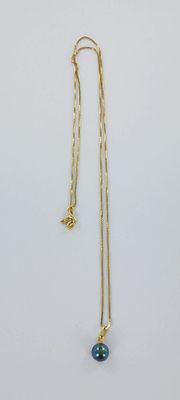 un collier en or orné d'une perle de verre bleue et d'une chaîne en or