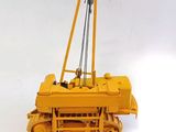 a yellow toy bulldozer sitting on a white surface