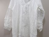 une photo d'une chemise blanche suspendue à un cintre accroché au mur