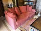 a pink couch sitting in the middle of a living room