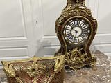 une horloge posée sur une table, à côté d'un bol