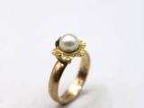 une image représentant une bague en or avec une perle au centre
