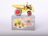 un petit camion jaune avec un homme à l'arrière