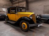une voiture jaune et noire dans un garage, à côté d'autres voitures