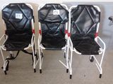 trois chaises pliantes noires et blanches placées les unes à côté des autres dans une pièce