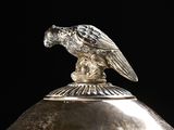 a silver object with a bird on top of it