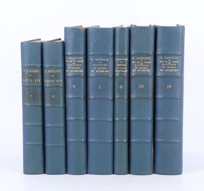 six livres bleus sont alignés sur une surface blanche