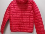 a red jacket hanging on a hanger on a wall